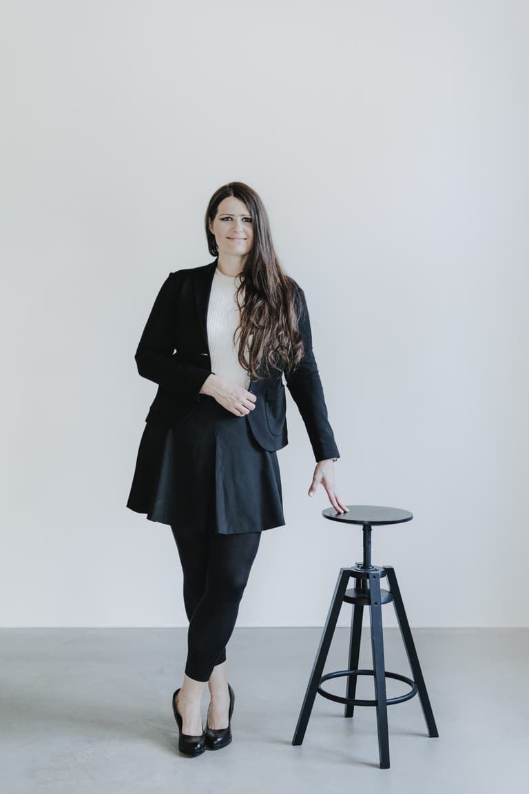 Dr. Alisha Rosenthal stehend an einem schwarzen Hocker
